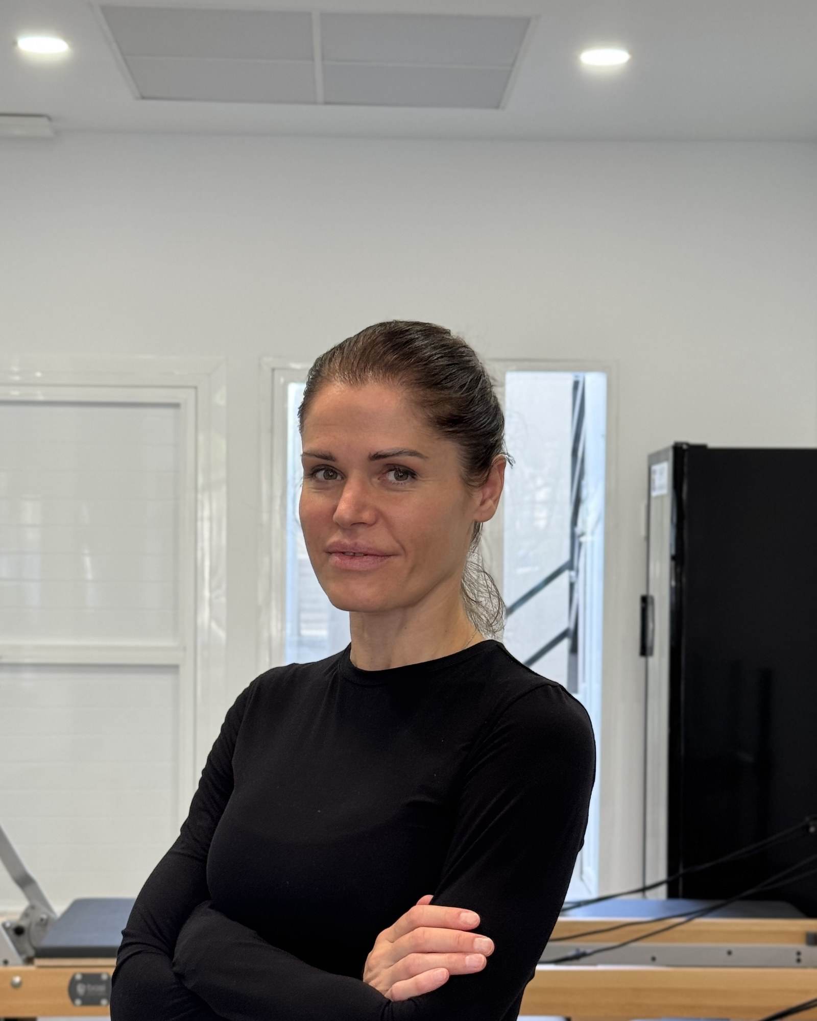Portrait of Inna, lead coach at BASI Pilates Alicante, in the reformer room