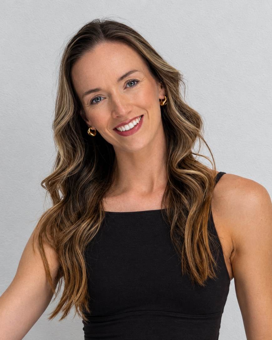 Portrait of Rachael, coach, smiling against a light background