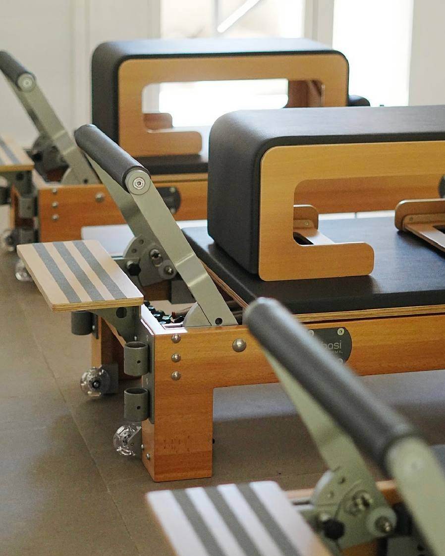 Close-up of a BASI Systems Reformer: footbar, springs and sitting box
