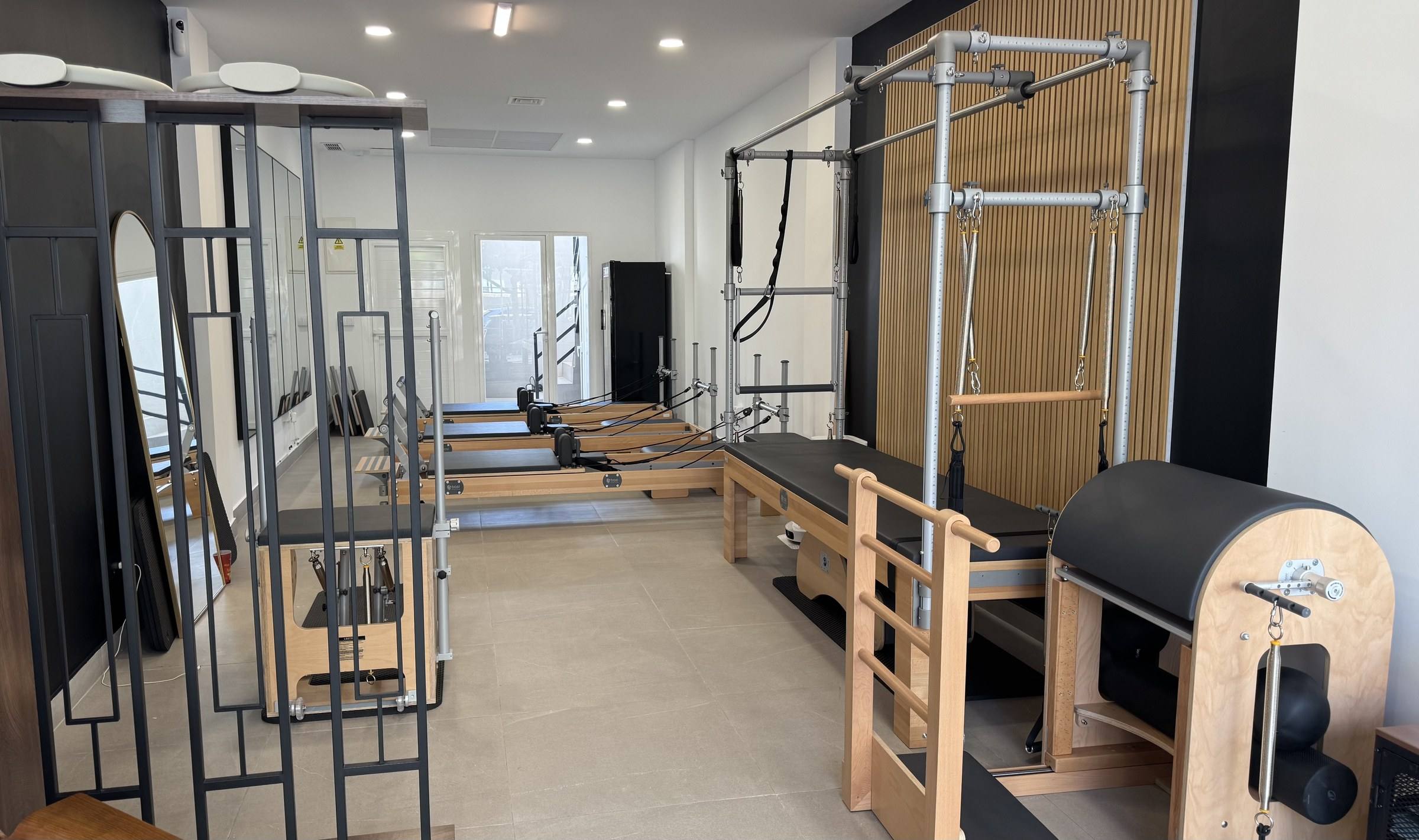 BASI Pilates Alicante studio with a Cadillac, Ladder Barrel and a row of wooden BASI Systems reformers